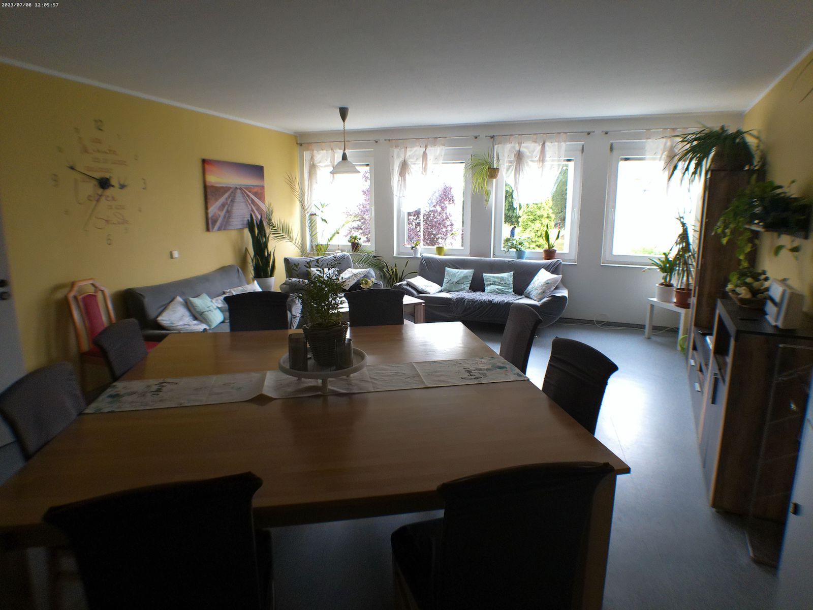 Ein Tisch mit 8 Plätzen steht im Raum und eine andere Sitzecke ist ebenfalls zusehen