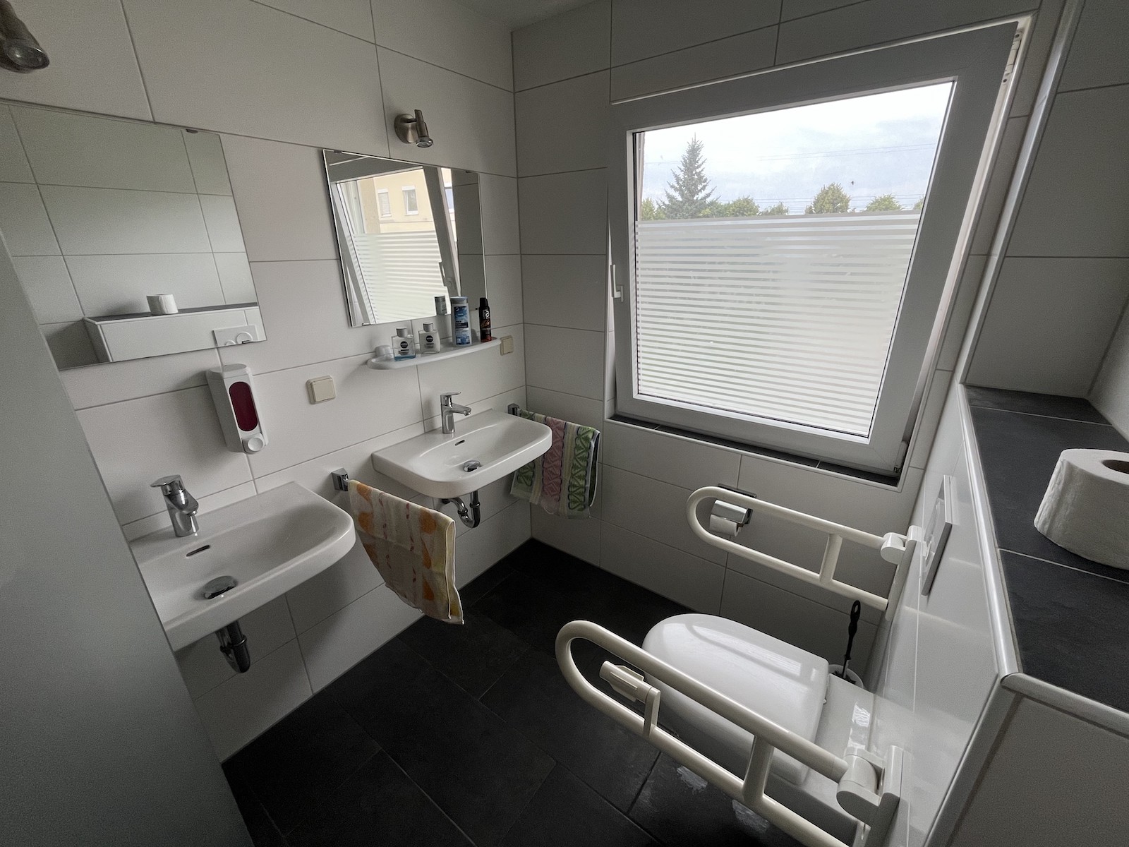 Ein Badezimmer mit zwei Waschbecken und einer Toilette